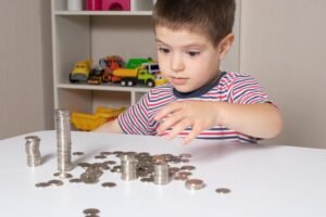 criancas aprendendo financas com moedas coloridas