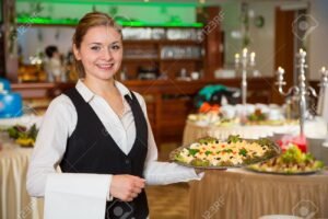funcionario sorridente servindo buffet elegante
