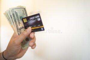 maos segurando cartao de credito e dinheiro