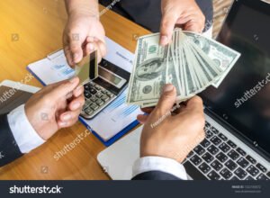maos trocando cartao de credito por dinheiro