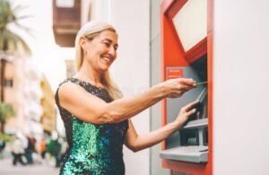 pessoa feliz retirando dinheiro em banco