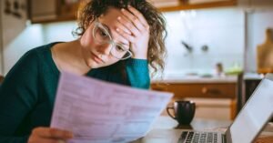 pessoa frustrada olhando extrato bancario