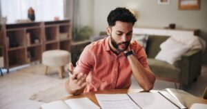 pessoa olhando extrato bancario com preocupacao