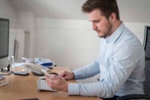 pessoa olhando para celular no ambiente de trabalho