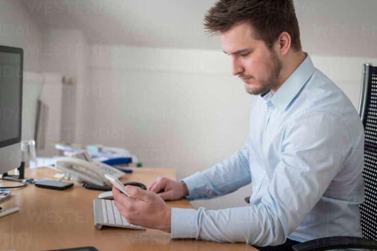 pessoa olhando para celular no ambiente de trabalho