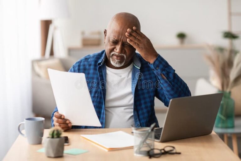 pessoa refletindo sobre documentos financeiros em mesa