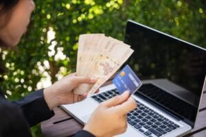 pessoa segurando carteira de trabalho e dinheiro