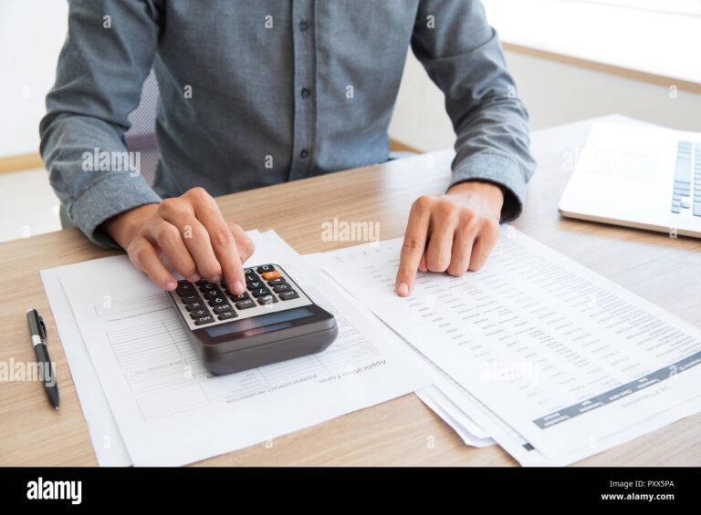 pessoa usando calculadora com documentos de trabalho