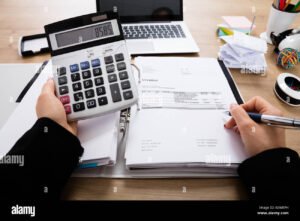 pessoa usando calculadora em mesa de escritorio