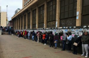pessoas em fila para atendimento financeiro publica